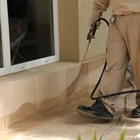 General pest control technician spraying exterior perimeter around a home in Provo, UT